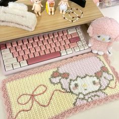 there is a hello kitty rug next to a keyboard and mouse on the computer desk