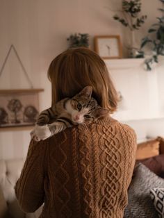 a woman holding a cat on her back