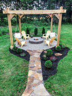 an outdoor fire pit surrounded by lawn furniture and string lights in the middle of a yard