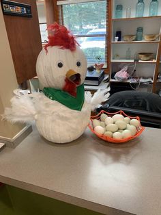 a large chicken sitting on top of a counter next to an egg bowl and plate