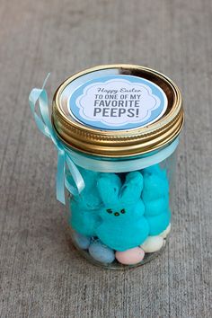 a jar filled with blue pees sitting on top of a carpet