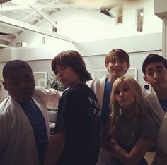 a group of young men and women standing next to each other in an office building