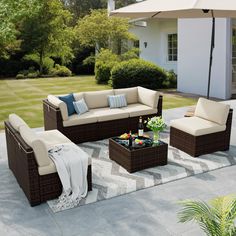 an outdoor living room with furniture and umbrella