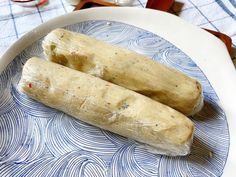 two tamales sitting on top of a blue and white plate