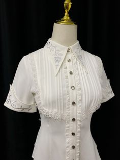 An embroidered blouse that looks like an aristocratic lady from medieval Europe. A cross and a rose are embroidered on the collar, and ivy is also embroidered on the cuffs. The back is decorated with lacework, and the chest is decorated with ruffles, pleats, and lace embroidery. For a young lady with a gorgeous atmosphere. 
 
 

 

 
 
 Color 
 
 White 
 Black 
 
 
 Size 
 
 
 S size 
 
 Length: 60cm 
 Shoulder width: 36cm 
 Bust: 86cm 
 Waist: 68cm 
 Sleeve length: 21.5cm 
 
 M size 
 
 Length: White Fitted Victorian Blouse, Fitted White Victorian Blouse, White Blouse With Floral Embroidery And Doll Collar, Elegant Lace Tops With Collar, Spring Gothic Formal Blouse, Spring Formal Gothic Blouse, Elegant Fitted Embroidered Tops, Elegant Embroidered Fitted Tops, Elegant Fitted Tops With Lace Cuffs