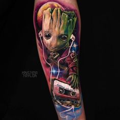 a tattoo with an image of a baby groote holding a radio and headphones