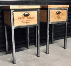 two wooden tables sitting next to each other in front of a black wall with metal legs