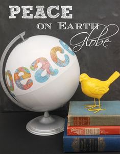 a yellow bird sitting on top of a stack of books next to a white globe