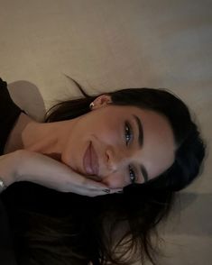 a woman laying on top of a bed next to a white wall