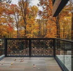 an outdoor deck with railings and trees in the background, surrounded by fall foliage