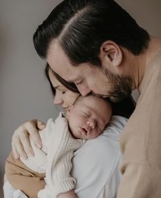 a man and woman holding a baby in their arms