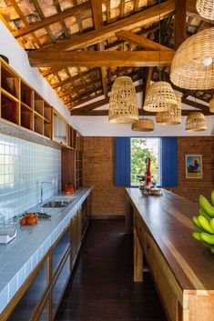 a kitchen with lots of counter space and hanging lights