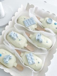 four ice cream pops decorated with icing and fondant decorations on top of each other