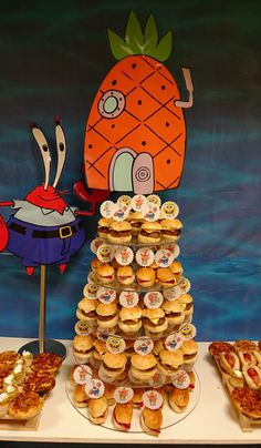 a table topped with lots of sandwiches and cupcakes