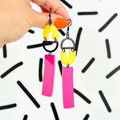 Go all out 80s with these statement earrings featuring a fun geometric design cut from glossy pink and yellow Perspex acrylic and oxidised brass. These dangly earrings hang from a nickel free black plated ear wire - perfect for sensitive ears. Although big, these statement earrings are super lightweight and comfortable to wear. Each pair is supplied with a pair of rubber earring backs.These earrings are very large and measure approximately 90mm x 21mm.  Perspex acrylic, nickel free iron, oxidise Cactus Jewelry, Large Dangle Earrings, Extra Long Necklace, Cactus Earrings, Laser Cut Jewelry, Nickel Free Jewelry, Retro Earring, Mismatched Earrings, Rainbow Earrings