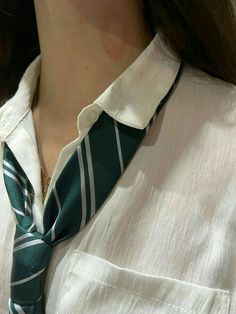 a woman wearing a white shirt and green tie