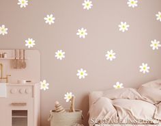 a bedroom with pink walls and white flower decals on the wall, along with a bed