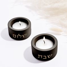 two black candles with hebrew writing on them