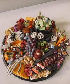 a platter filled with lots of different types of food and halloween decorations on top of it