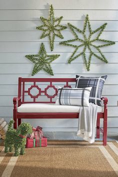 a red bench sitting on top of a wooden floor next to a white wall covered in snowflakes