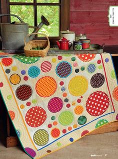 a table with a colorful quilt on it