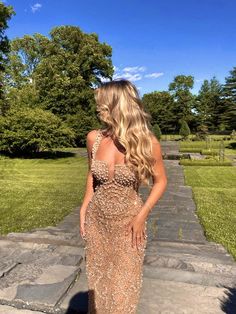 a woman in a long dress is standing on some steps and looking down at the ground