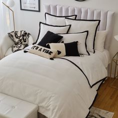 a white bed with black and white pillows