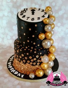 a black and gold birthday cake with pearls on the top is decorated with a clock