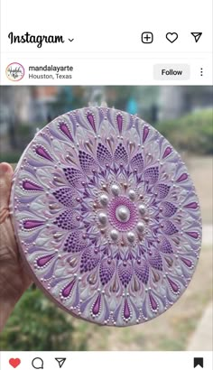 a hand holding a purple glass plate with white designs on the front and bottom, which reads instagram