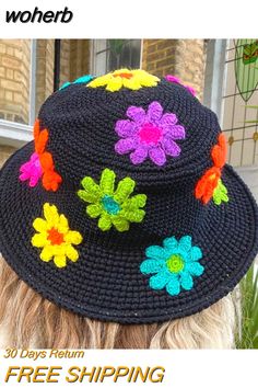 a woman wearing a black crocheted hat with multicolored flowers on it