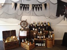 there are many bottles of wine on display in this room with banners above them and other items for sale