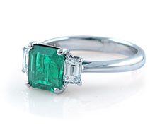 an emerald and diamond three stone ring