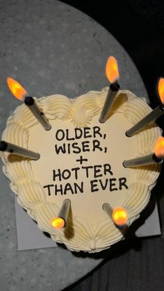 a heart shaped cake with candles on it that says older, wiser, and shorter than ever