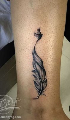 a black and white feather tattoo on the leg