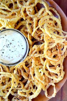 some onion rings with a small bowl of dip