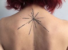 the back of a woman's neck with a star tattoo on it