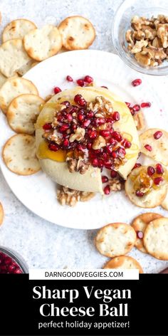 a white plate topped with crackers covered in cheese and pomegranates