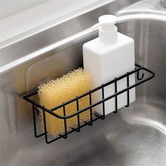 a sink that has some soap and a sponge in the basket on top of it