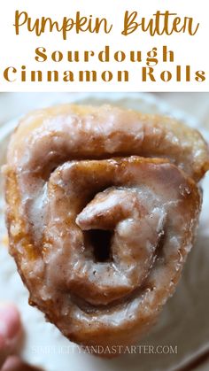 pumpkin butter sourdough cinnamon rolls on a white plate with text overlay that reads pumpkin butter sourdough cinnamon rolls