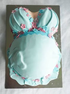 a cake with blue frosting and pink flowers on the top is shaped like a woman's head