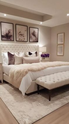 a white bed sitting on top of a wooden floor next to two pictures above it