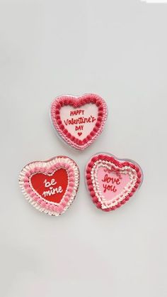 three heart shaped cookies sitting on top of a table