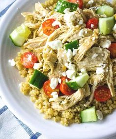 a white plate topped with chicken and veggies on top of couscous