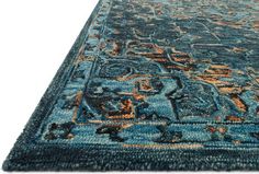 a blue rug with an intricate design on the top and bottom, in front of a white background