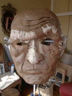 a sculpture of an old man's face is shown in the middle of a room