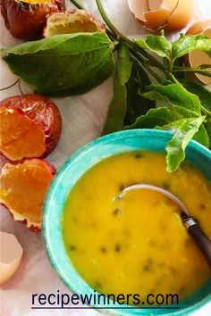 a blue bowl filled with soup next to oranges