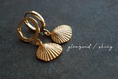 "Gold plated earrings with shell pendants. You can choose from two different earhooks (see picture number 2): 1: 12 mm hooks 2: 16 mm Creoles Also you can choose the style of the shell-charms: matt shiny M A T E R I A L gold-plated brass S I Z E Shiny gold plated Creoles: 0.6 inch / 16 mm in diameter Shiny gold plated Leverbacks: 12 mm in diameter Matt or shiny gold plated Shell pendants: 10 x 12 mm ------------------------------------------------------------------------------------------------- Elegant Gold Shell With Lobster Clasp, Nickel-free Shell-shaped Earrings Gift, Gold Shell With Matching Earrings Gift, Elegant Gold Shell As Gift, Handmade Gold Dangle Shell, Handmade Gold Shell As Gift, Handmade Gold Shell Gift, Elegant Shell-shaped Gold Hoop Earrings, Elegant Gold Dangle Shell Earrings