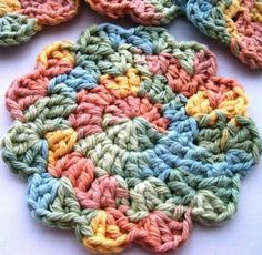 crocheted coasters with multicolored circles on white table top next to each other