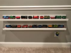 the toy trains are lined up on the shelves in the children's playroom