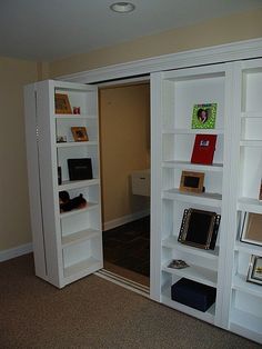 an empty room with bookshelves and pictures on the wall